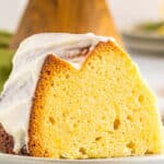 lemon pound cake on a white plate covered in cream cheese frosting