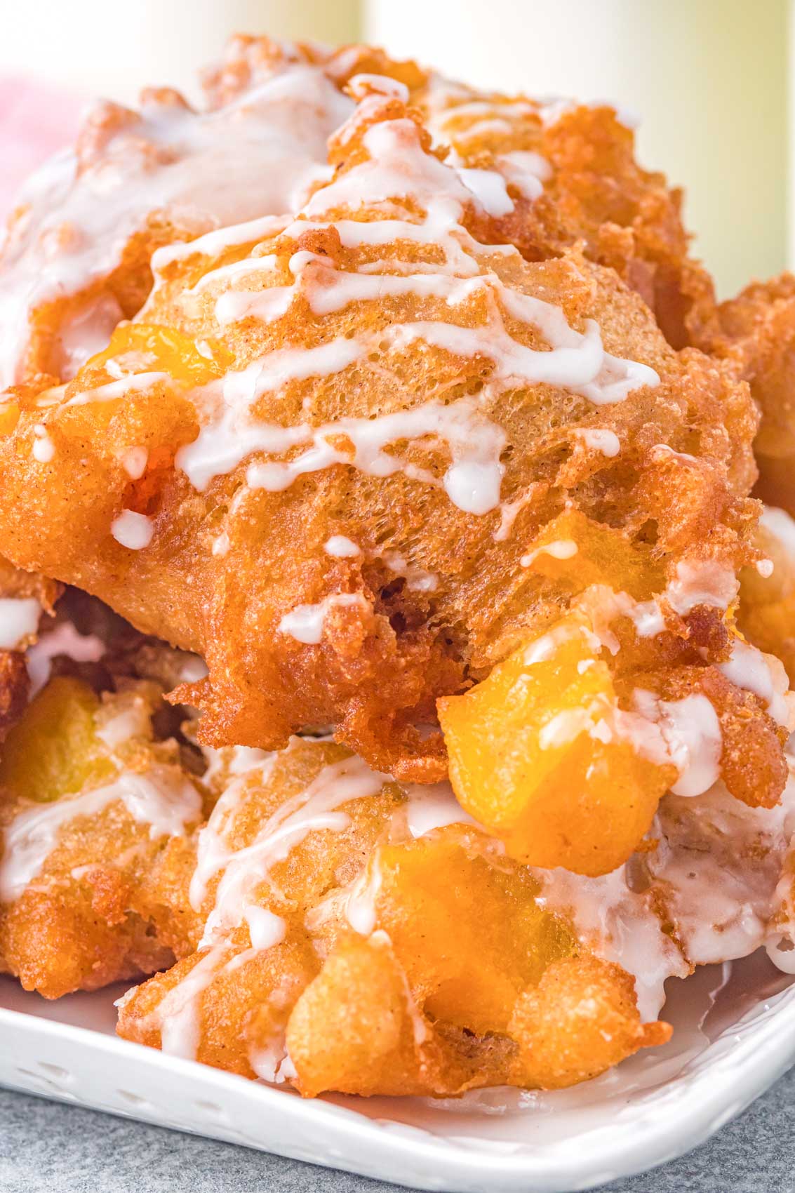 close up image of a peach fritter with sweet glaze