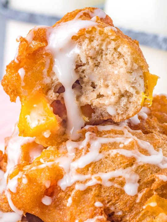 peach fritter cut open with icing drizzled down the side