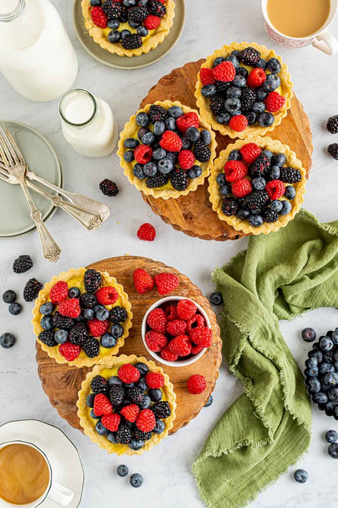 overhead shot of fruit tartlets with berries scattered about