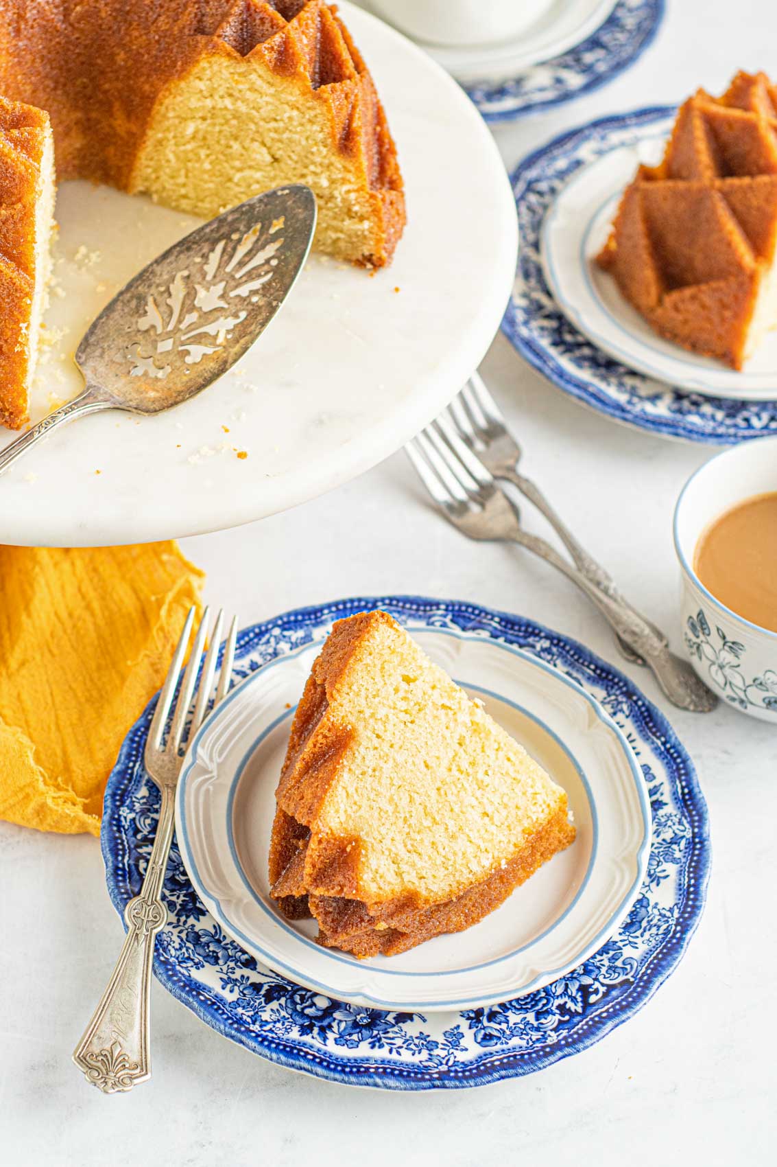 slice of Kentucky Butter Pound Cake on a blue plate next to a cake stand