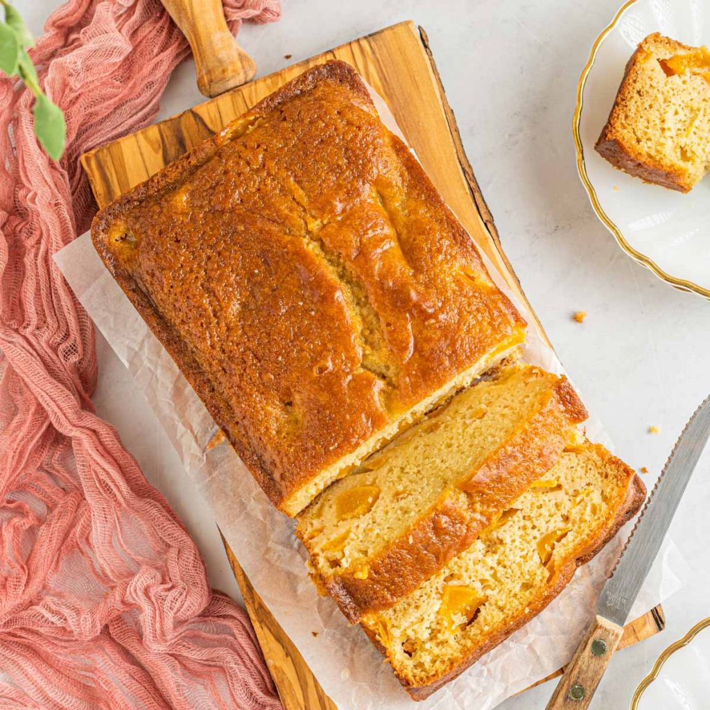 sliced load of peach bread with a butter knife and a pink linen