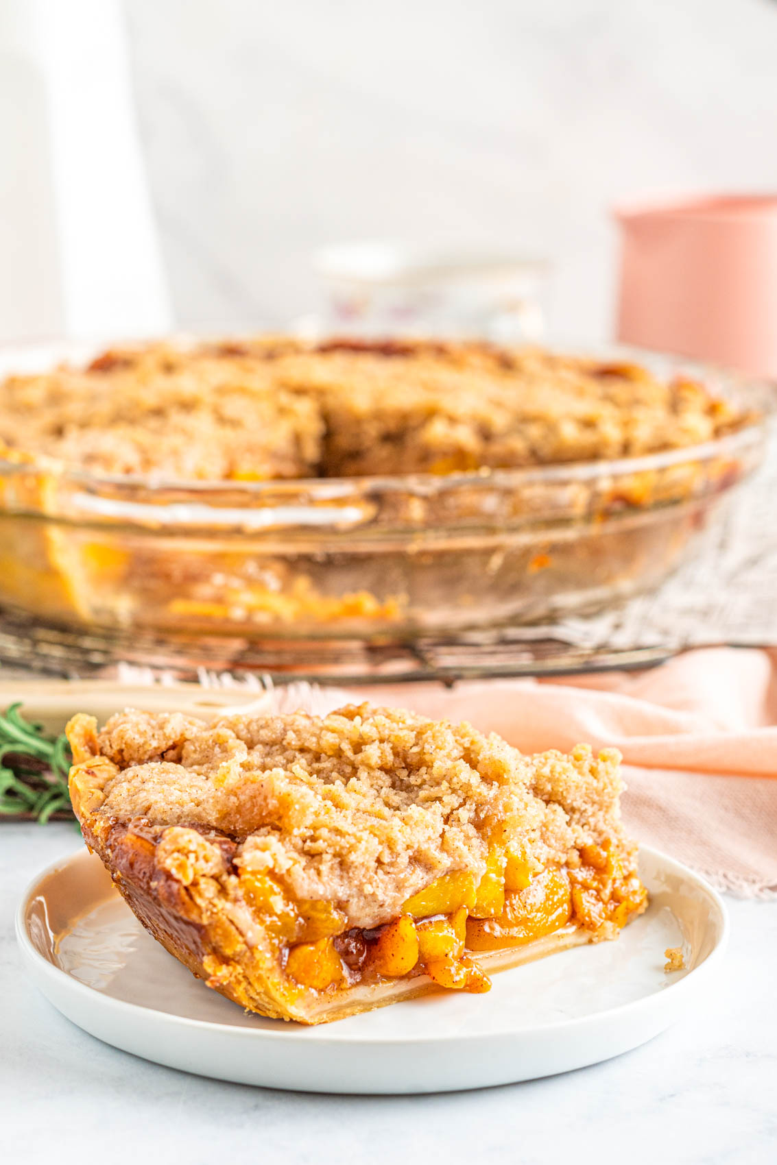 thick slice of peach pie with crisp topping