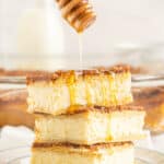 honey drizzling over three stacked sopapilas cheesecake bars