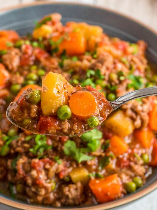 instant pot vegetable hamburger soup in a bowl with a spoonful being lifted
