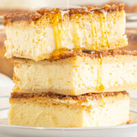 honey drizzled on top of a stack of sopapilla cheesecake bars