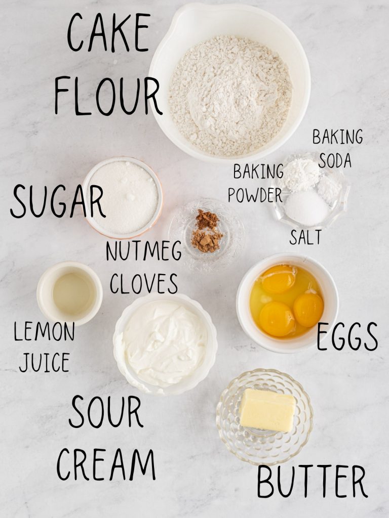 ingredients for sour cream donuts, including butter, cake flour, nutmeg, eggs, lemon juice, baking powder, cloves, and sugar