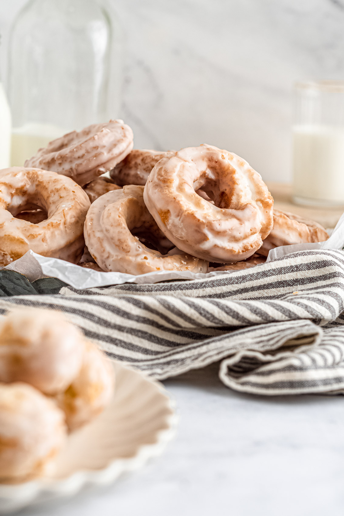 stack of crackled old-fashioned sour cream donuts sitting on a linen