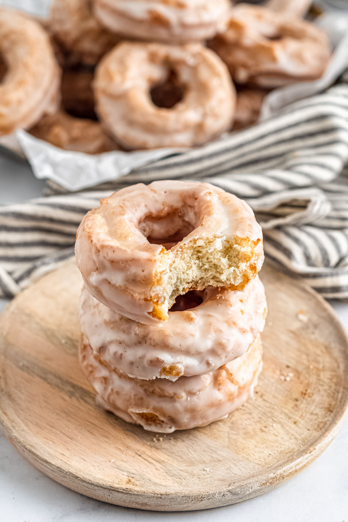 three donuts in a stack with the top one having a bite taken out, revealing a cake-like texture