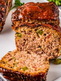 thick glazed meatloaf sliced open revealing green peppers inside