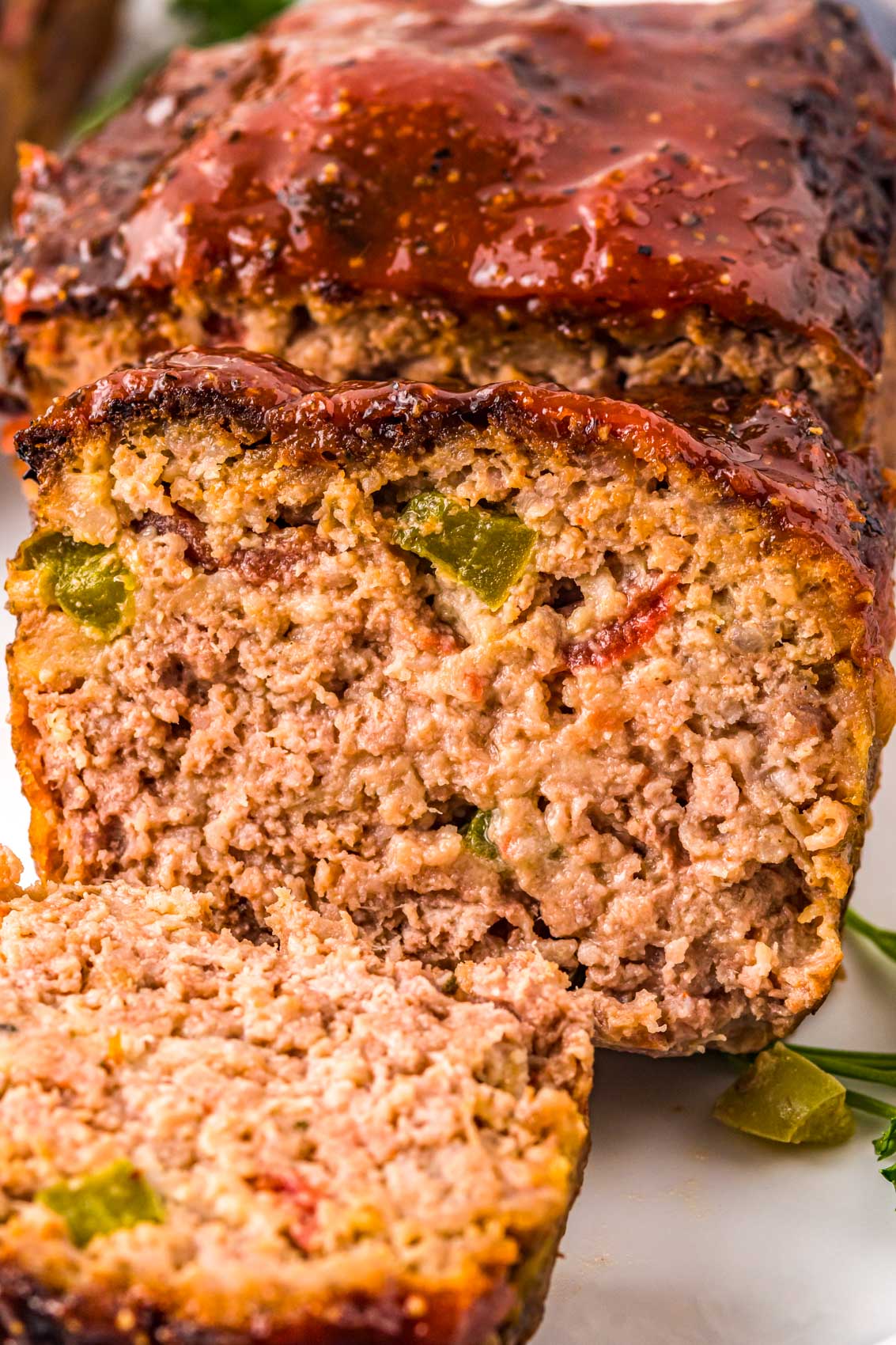 meatloaf with tomatoes and peppers inside, topped with a thick red shiny glaze