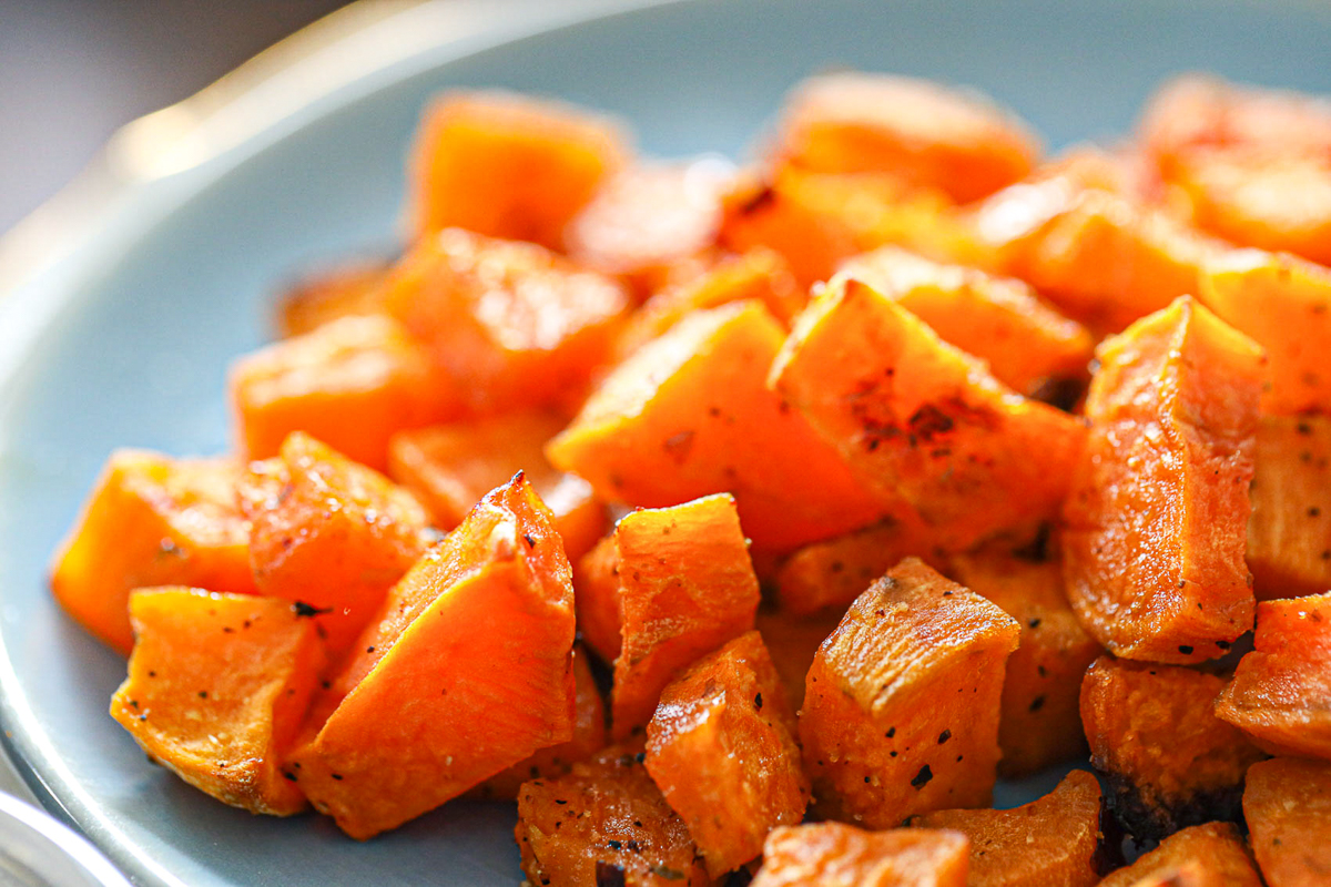 crisp sweet potato cubes with red pepper and ground black pepper on top