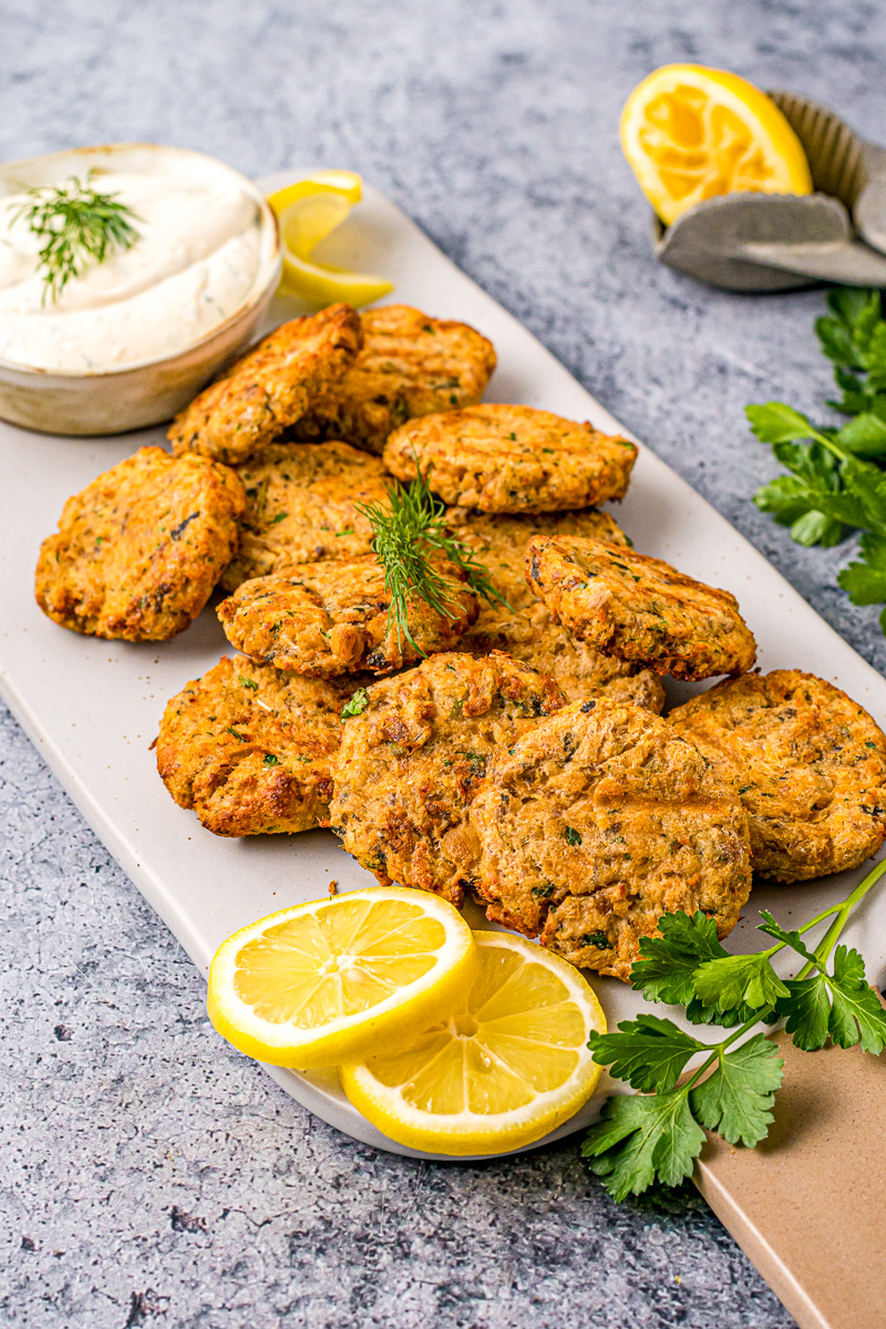 thick salmon patties next to creamy dill sauce