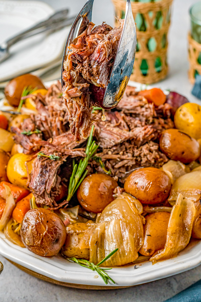 tongs grabbing roast and juices