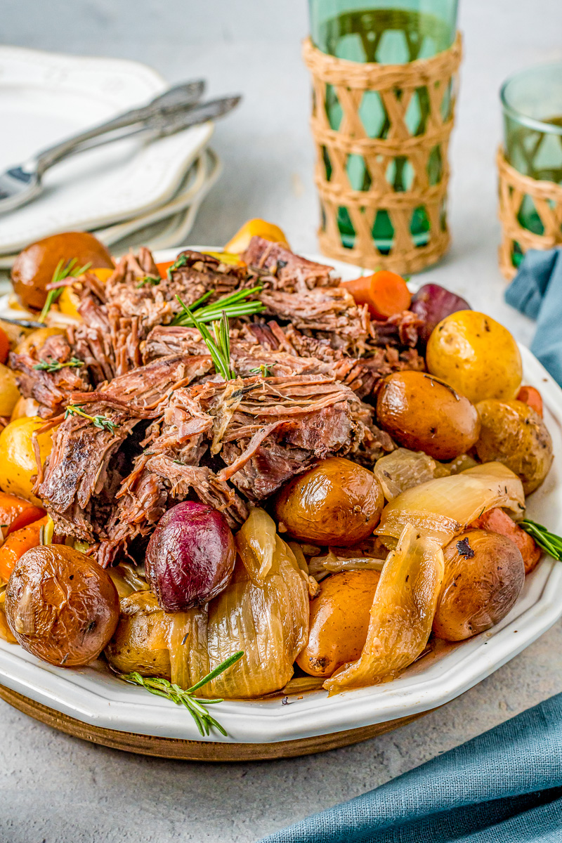 tender onion, potatoes and carrots surrounding a pot roast