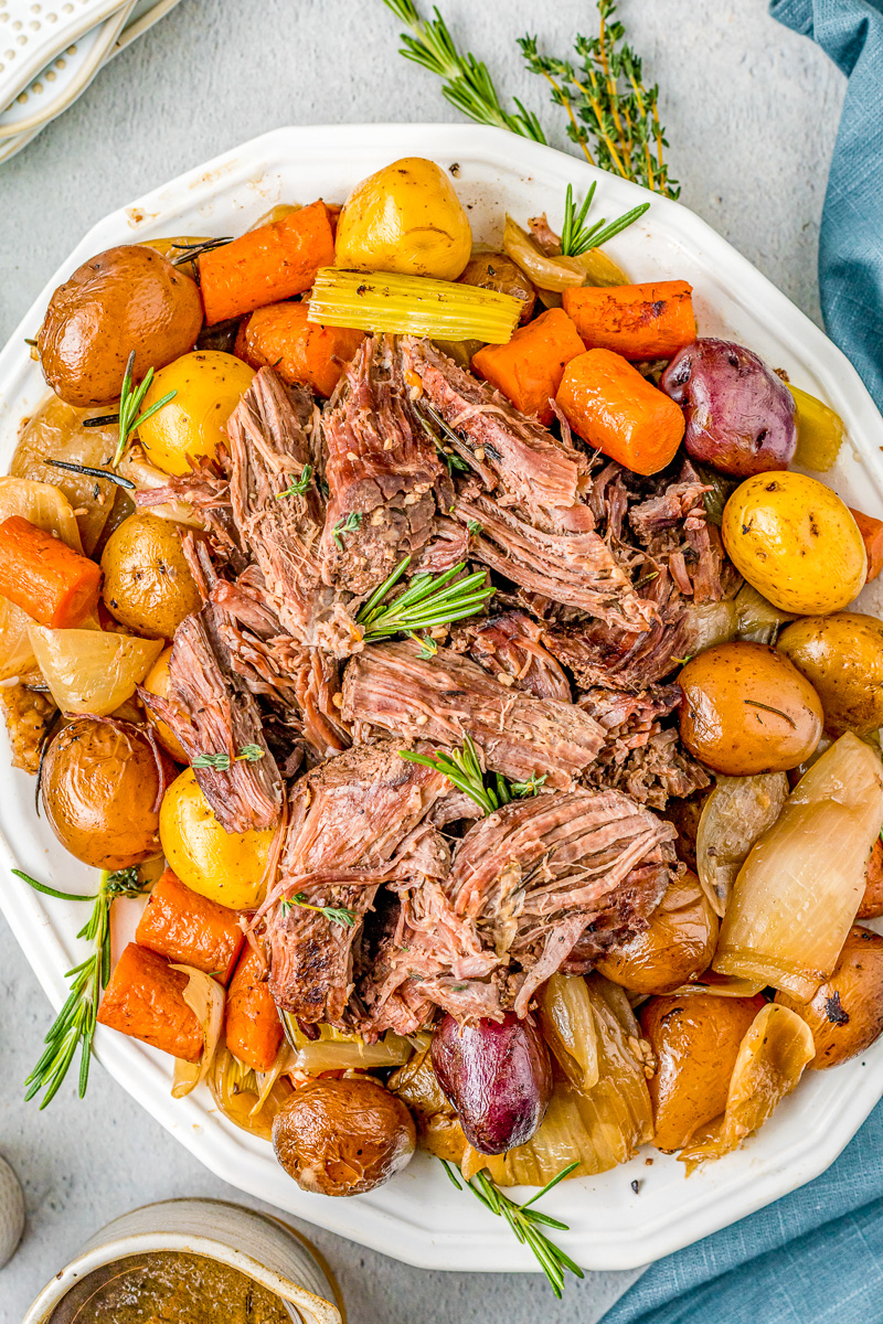 tender, pull-apart chuck roast with potatoes and carrots and rosemary as garnish