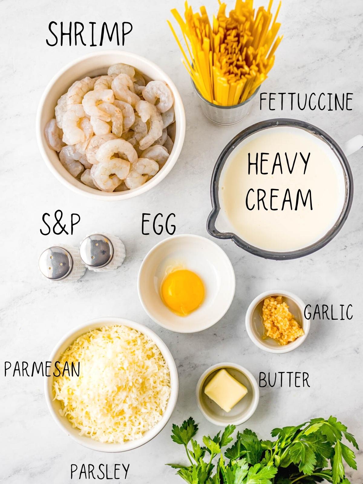 ingredients for shrimp Alfredo, including eggs, fettuccine, garlic and heavy cream