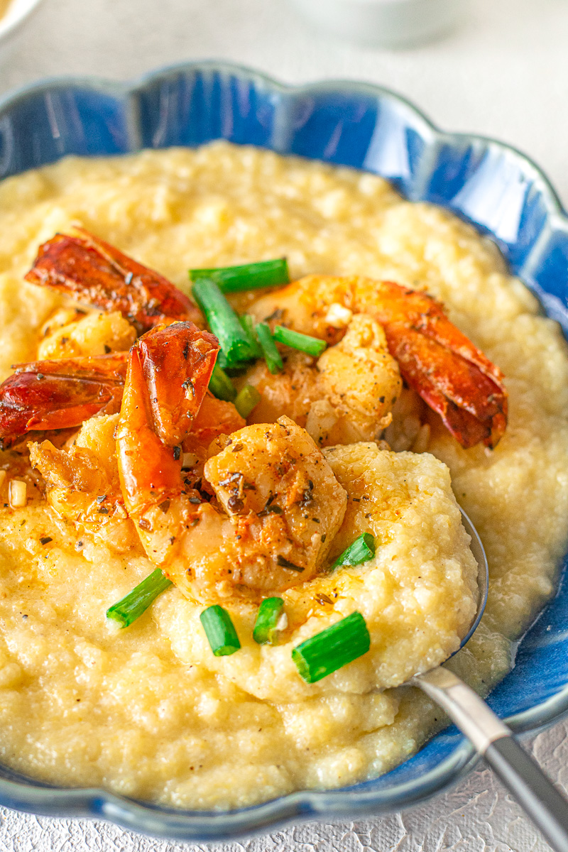 creamy cajun shrimp and grits in a bowl with green onion as a garnish