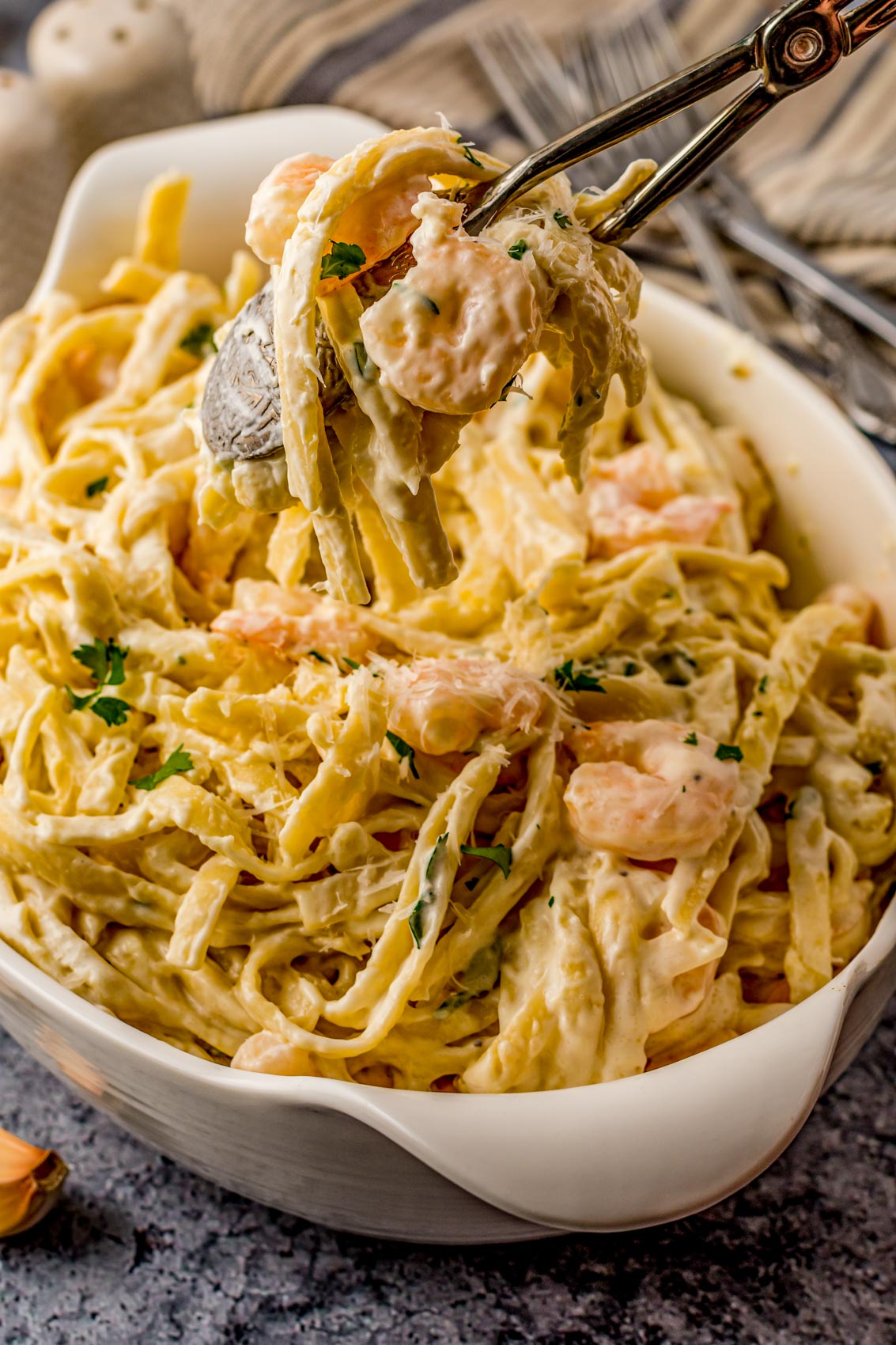 tongs with Alfredo pasta and shrimp