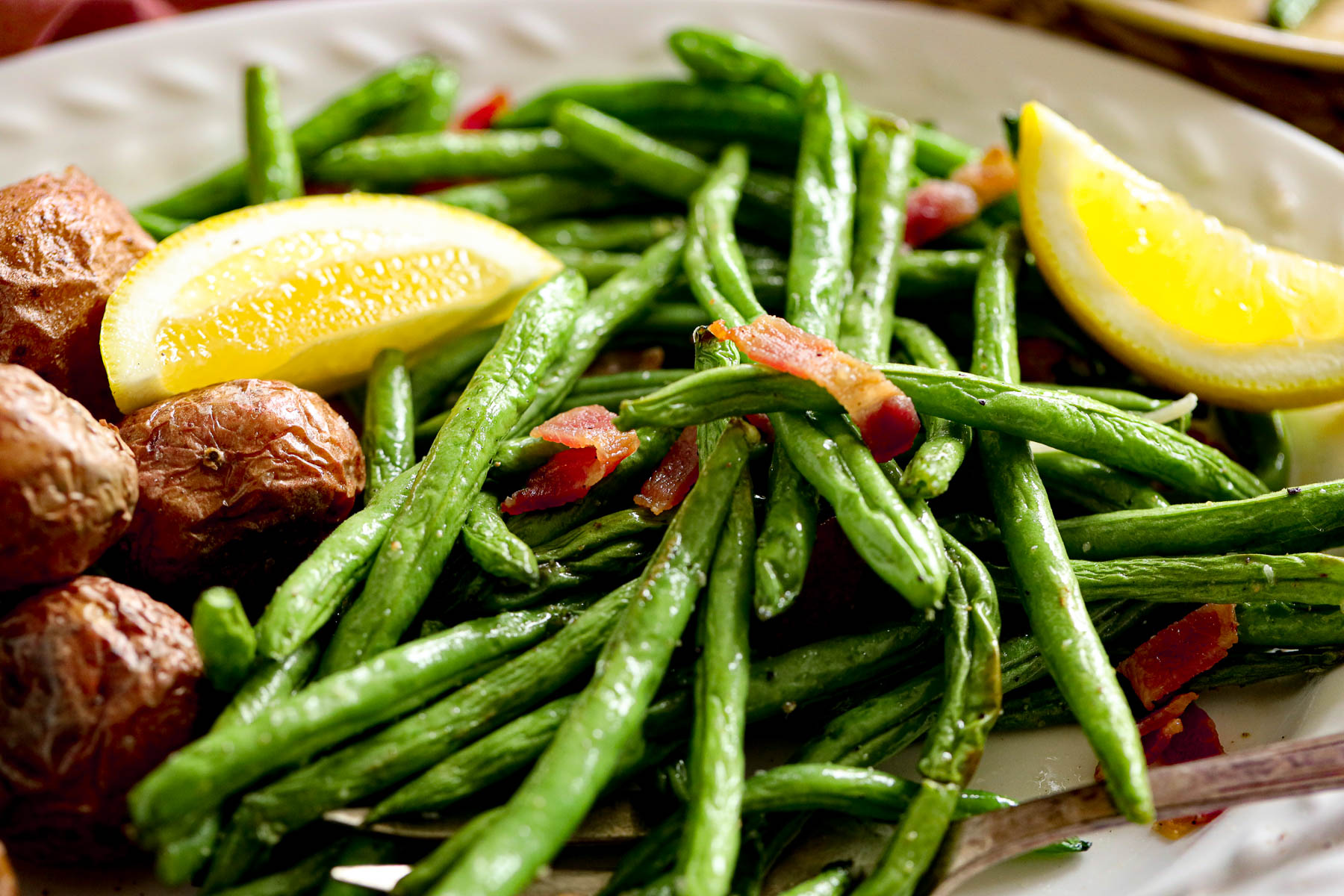 green beans with bacon bits and lemon wedges