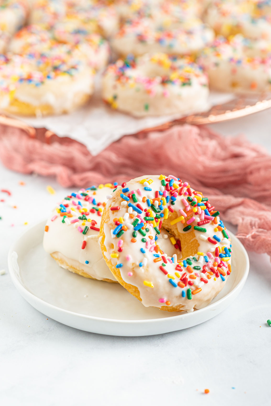 donuts on a plate with sprinkles and frosting