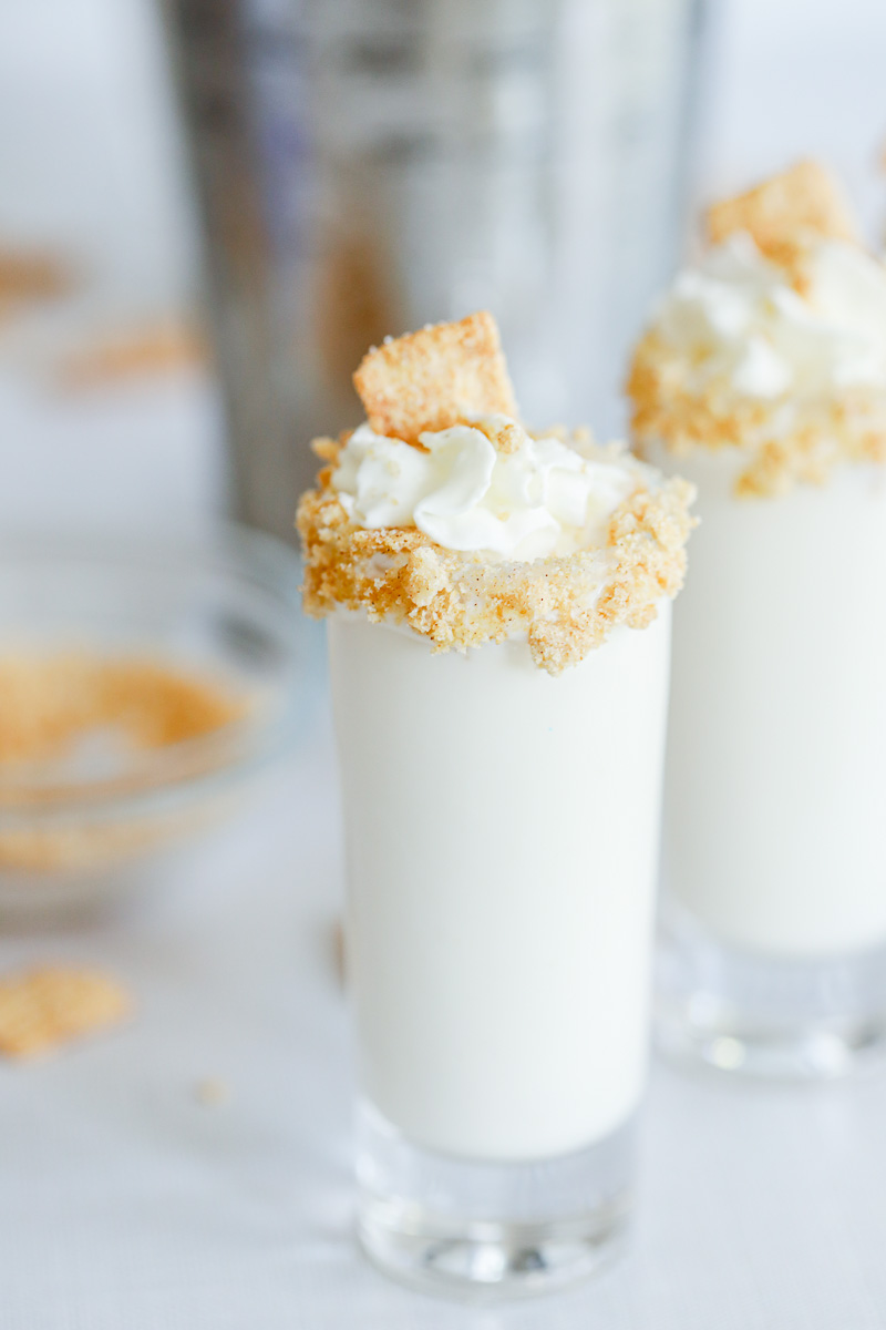 Cinnamon Toast Crunch cocktail shots topped with cereal crumbs and whipped topping