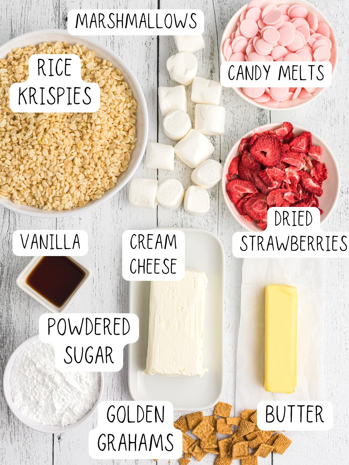 ingredients for strawberry cheesecake rice krispies, including candy melts, dried strawberries, rice krispies, butter, marshmallows and cream cheese