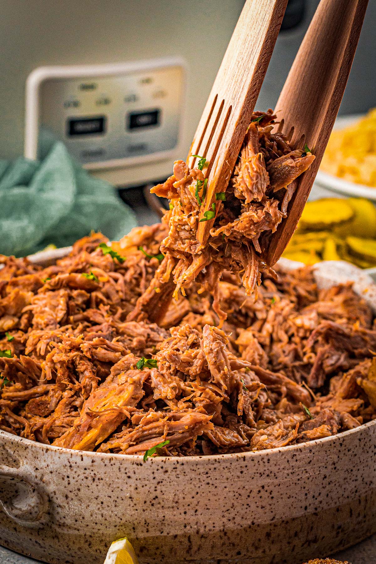 tongs lifting up pulled pork