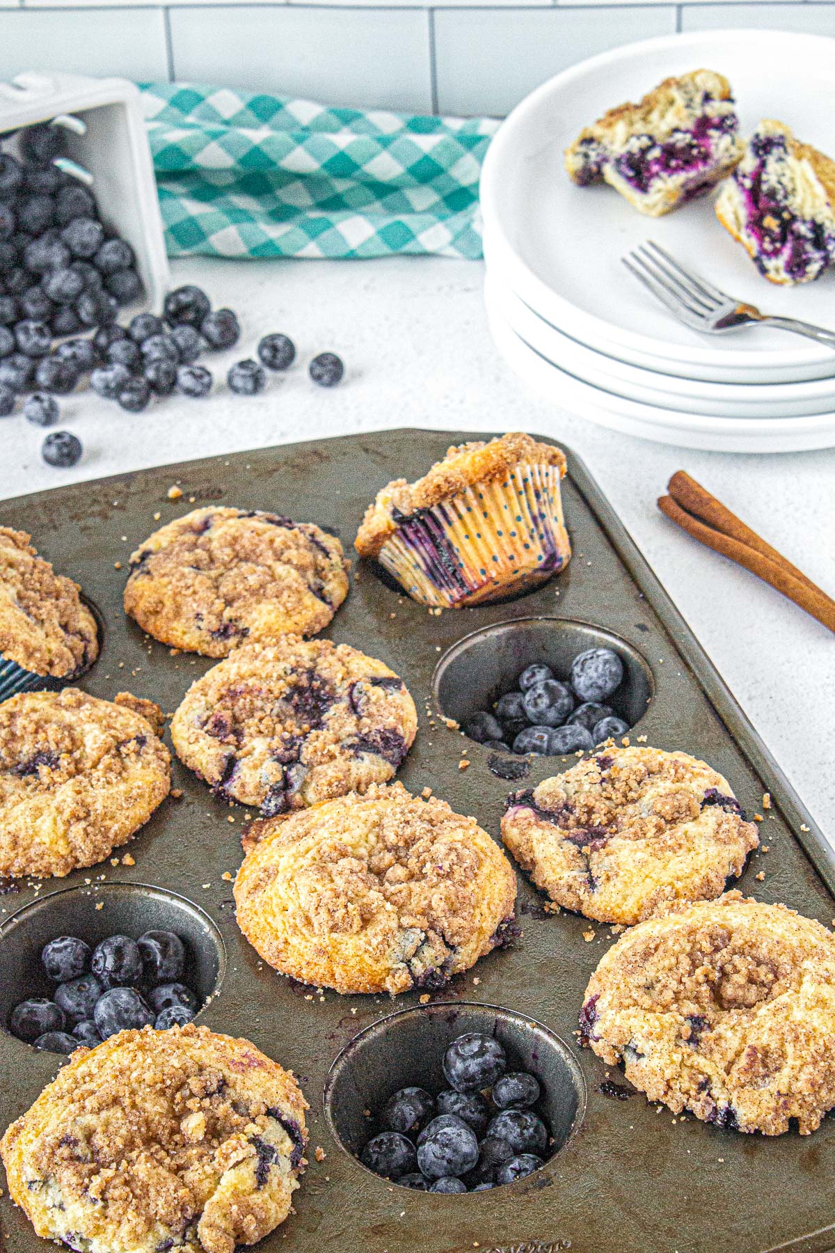 blueberry crumble muffins in a pan with cinnamon and blueberries