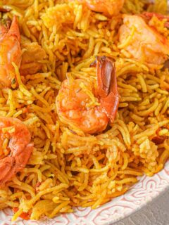 shrimp biryani in a large bowl with rice