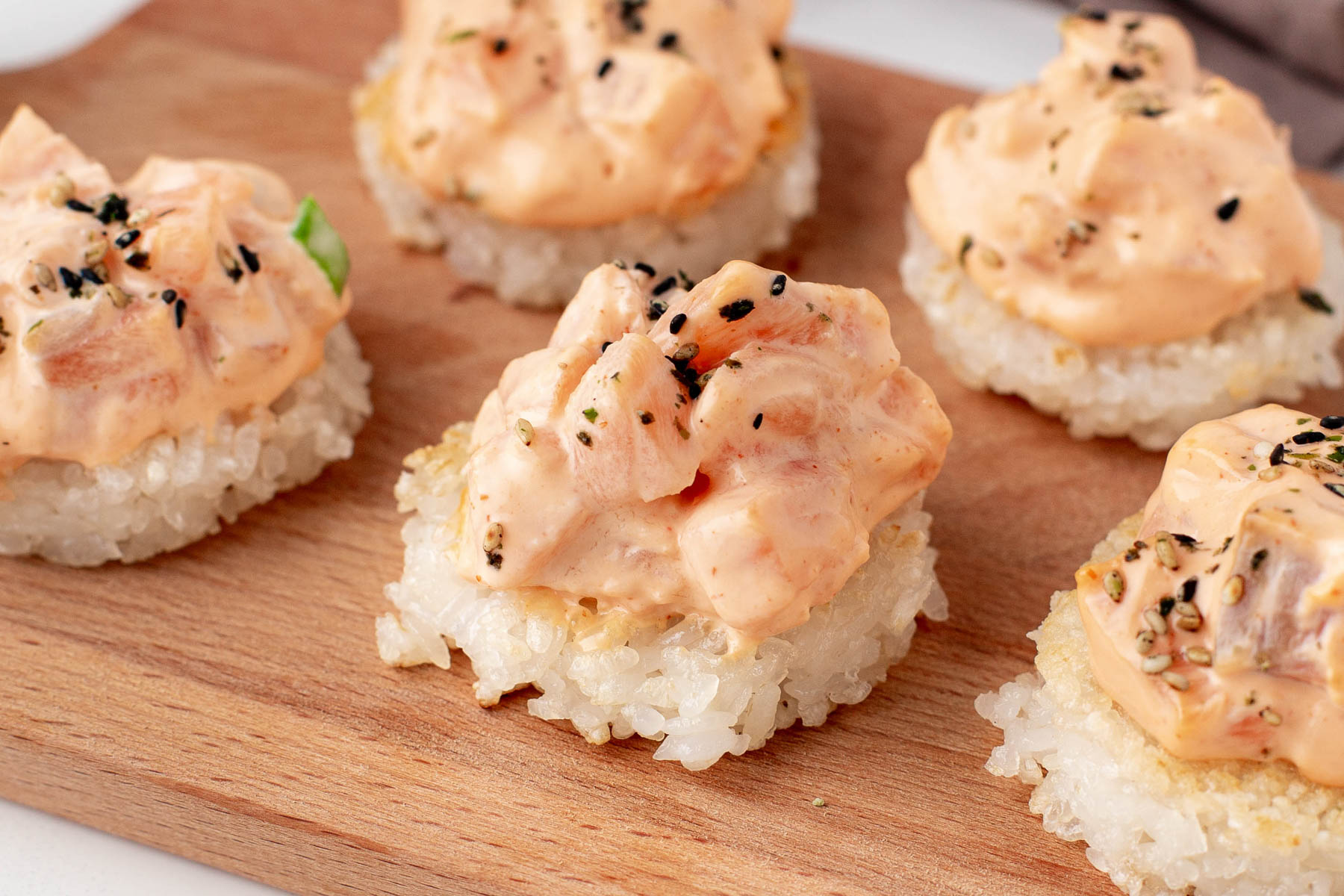 salmon bites with rice on a wooden platter